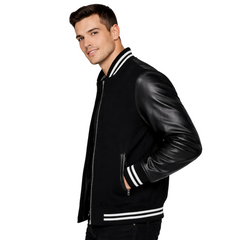 Man wearing a black varsity jacket with leather sleeves on a white background